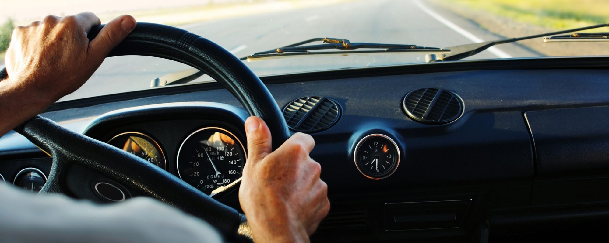 Un homme au volant d'une voiture sur la route