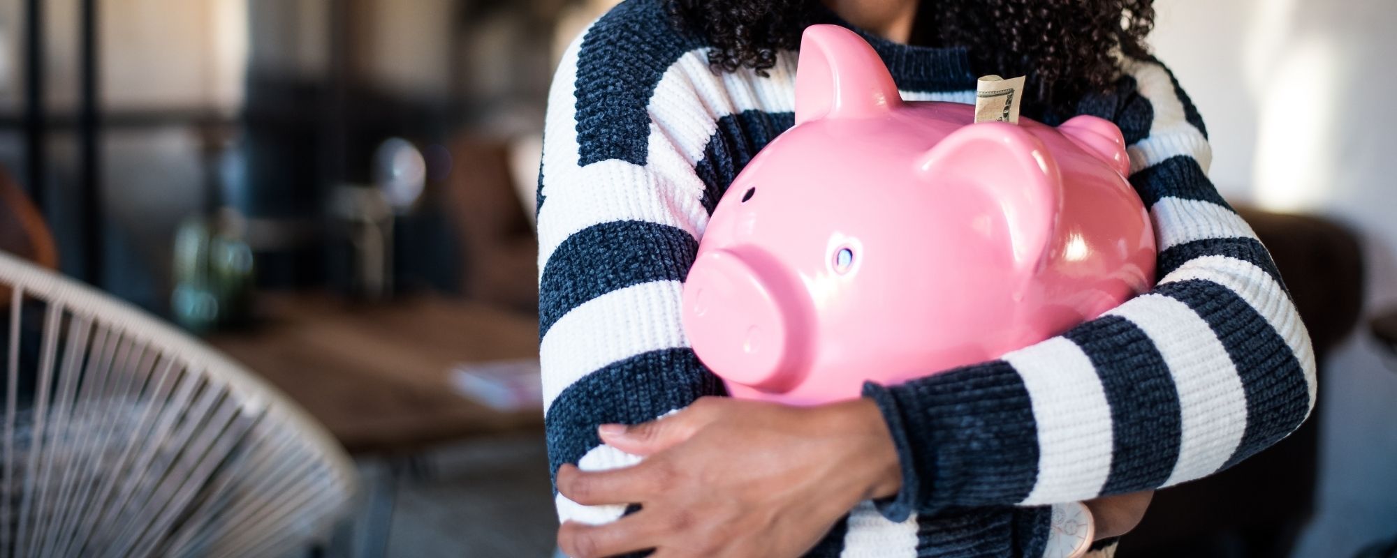 femme tient une tirelire cochon