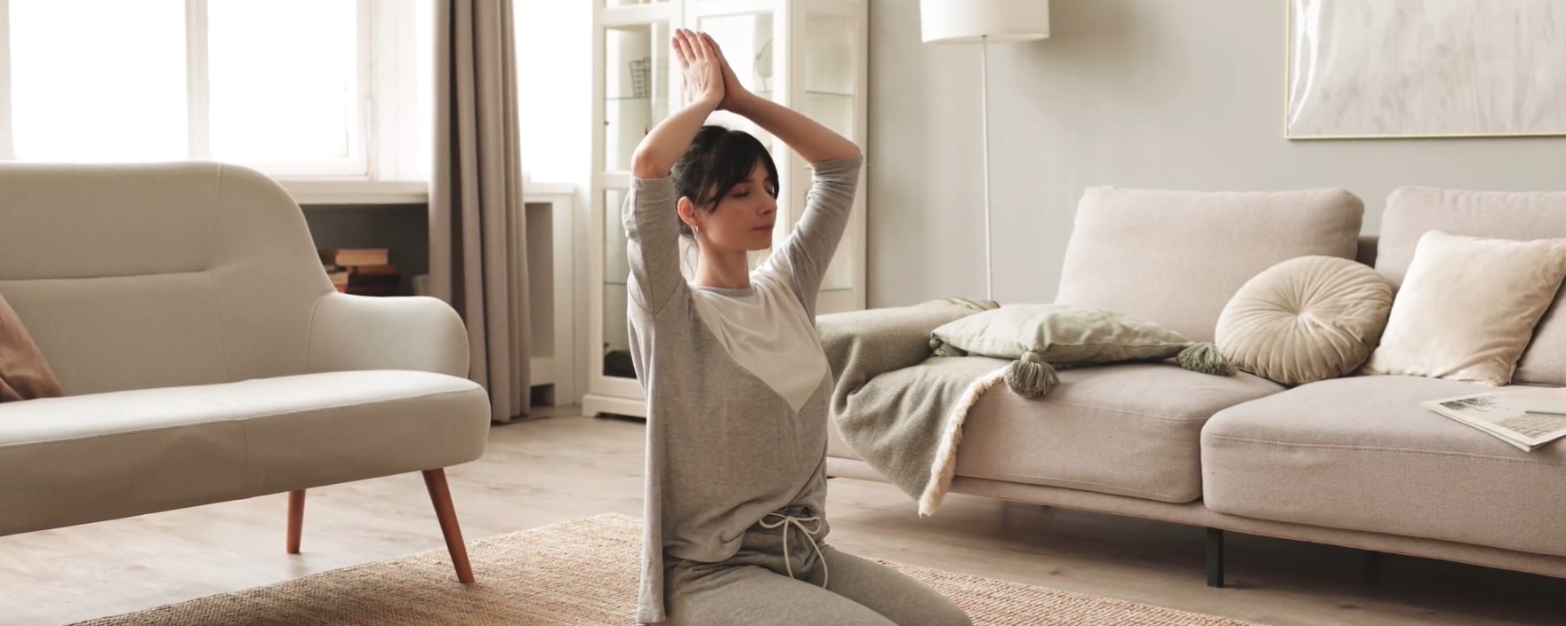 une femme fait du yoga dans son salon