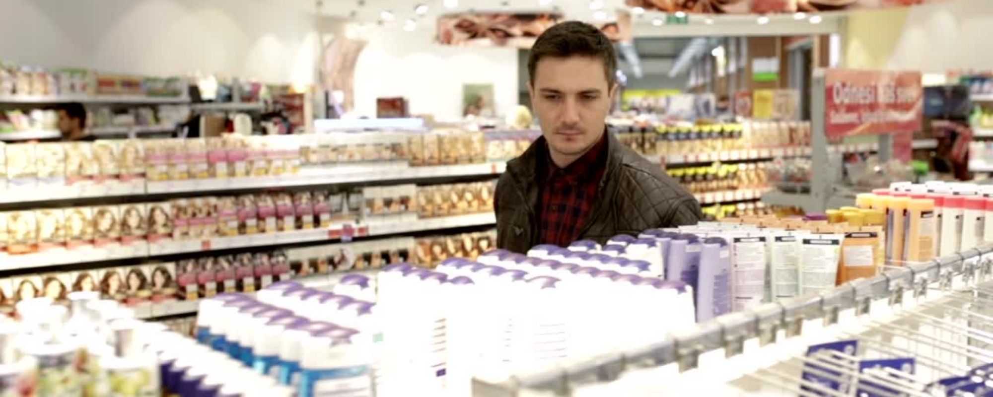 Un homme dans un rayon beauté dans un supermarché