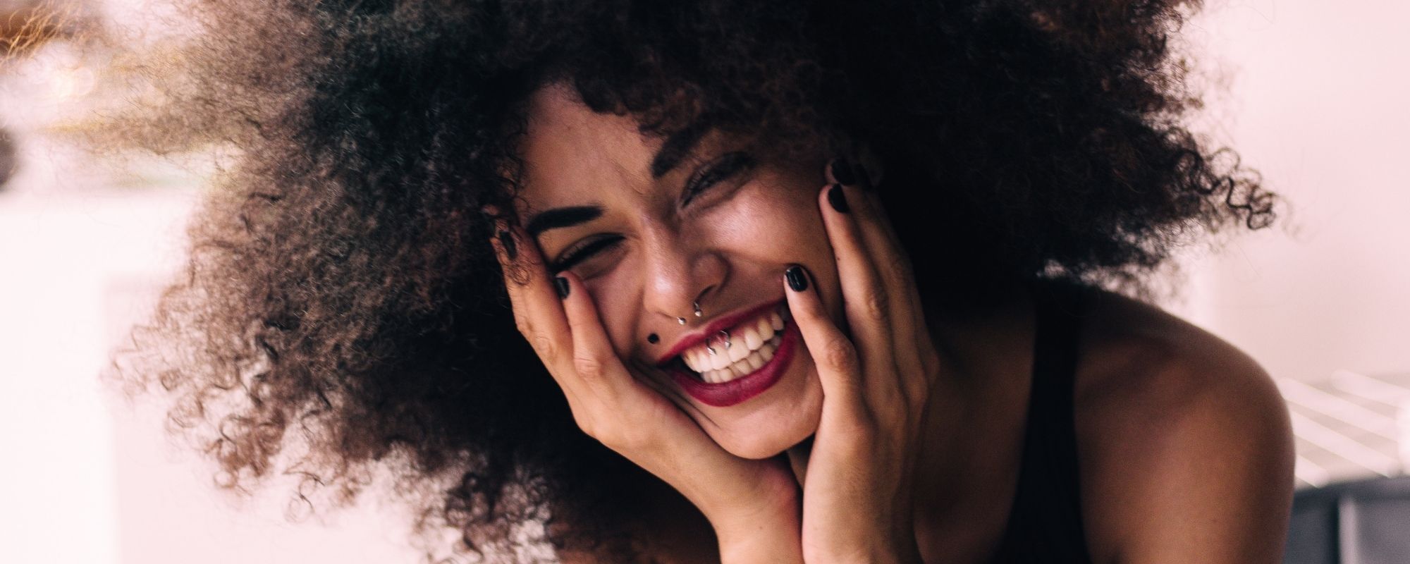 femme contente touche ses cheveux bouclés